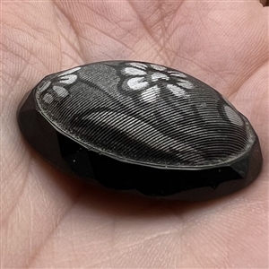 Oval imitation fabric black glass button.