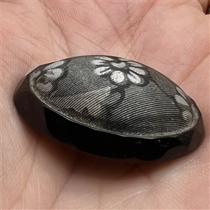 Oval imitation fabric black glass button.