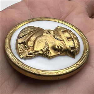 White glass button with an escutcheon of a man’s head.