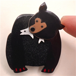 Janet White’s “Black Bear with Supper” enamel on copper studio button.