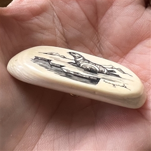 Scrimshaw button of a seal on natural material.