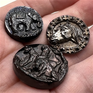 Three black glass buttons of animals.