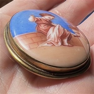 Ceramic oval button of a little girl sewing.