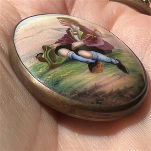 Ceramic oval button of a little boy holding his hat.