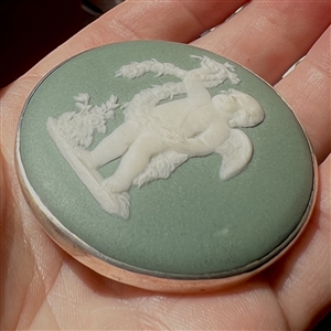 Extra large Wedgwood button of a cherub with a wreath.