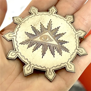 Huge chased and silvered metal button of the “Eye of Providence.”