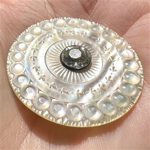 An 18th c. carved mother of pearl button with faceted paste center.