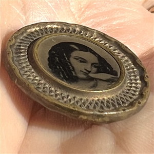 Tintype button of a girl kissing a bird.