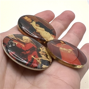 Three studio buttons of famous people under resin.