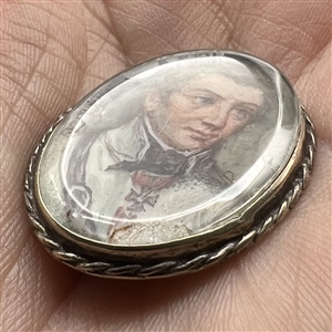 An 19th c. painting under glass of a man set in unmarked silver button.