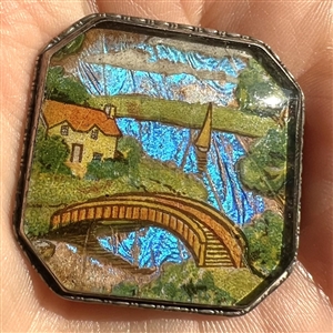 Reverse painted lake scene with bridge and sail boat with real butterfly wing background button.