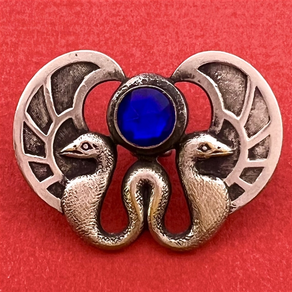 Silvered brass button of two birds and cobalt glass “jewel.”