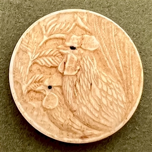 Carved natural material button of two chickens.