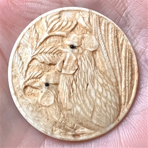 Carved natural material button of two chickens.