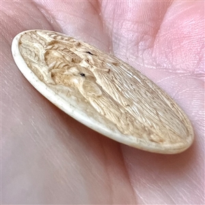 Carved natural material button of two chickens.