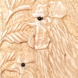 Carved natural material button of two chickens.