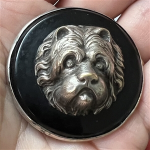 Large sculptural white metal escutcheon of a dog over plastic button.