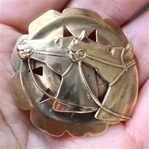 Brass button with two horse heads escutcheon.