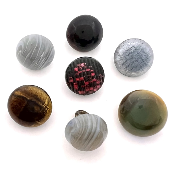 Seven glass buttons including rosette-shanked glass and others.