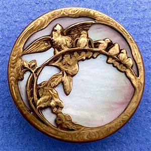 Iridescent shell button with birds on a branch.