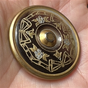 Iridescent brown pearl button with incised design.