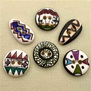 Six assorted hand-painted glazed ceramic buttons.