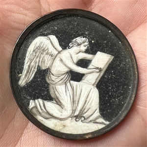 An 18th c. “en grisaille” painting  on natural material button of an angel writing a list.