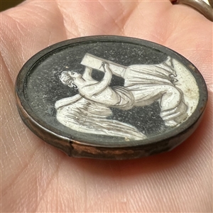 An 18th c. “en grisaille” painting  on natural material button of an angel writing a list.