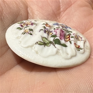 An 18th c. Transitional Mennecy ceramic button of flowers.