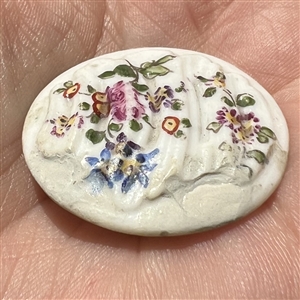 An 18th c. Transitional Mennecy ceramic button of flowers.