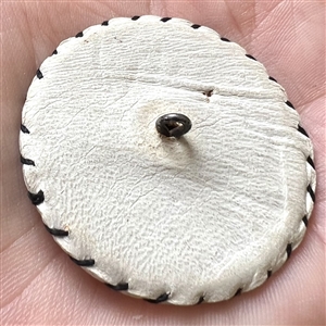 Vintage white leather button with musical instruments.