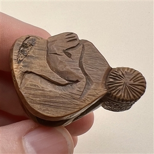 Seated man with basket netsuke.