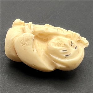 Man holding a fish netsuke.