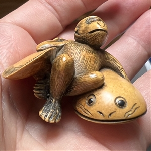 Monkey holding a fish netsuke.