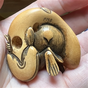 Monkey holding a fish netsuke.