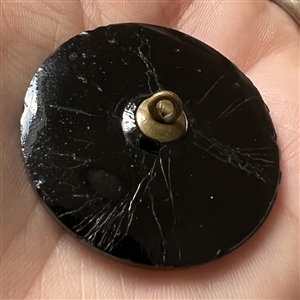 Black glass button of “Stag Hunt.”