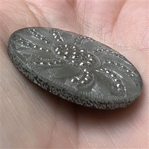 Lacy glass button with an interesting pattern.