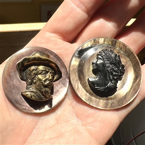 Two smoky pearl buttons of heads.
