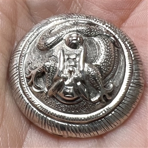 Highly sculptural silver button of a dragon.