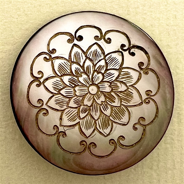 Grey pearl button with incised design of flower.