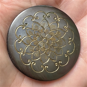 Grey pearl button with incised design of flower.