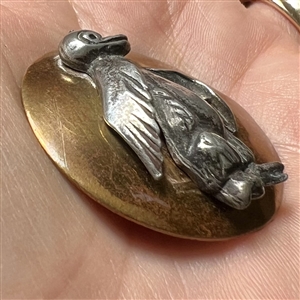 Brass and white metal penguin button.