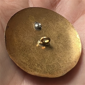 Brass and white metal penguin button.
