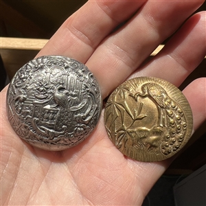 Two metal buttons of peacocks.