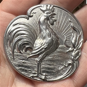 French white button of rooster crowing at dawn.