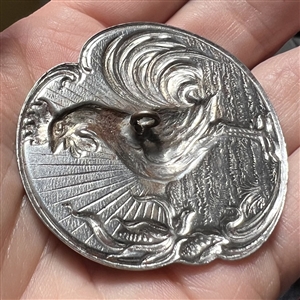 French white button of rooster crowing at dawn.