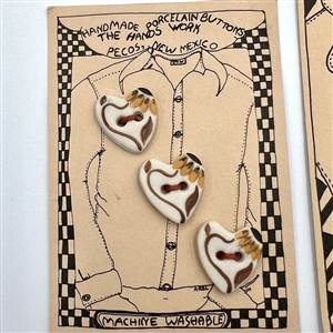 Four cards of “Hands Work” ceramic buttons of assorted objects and fruit.