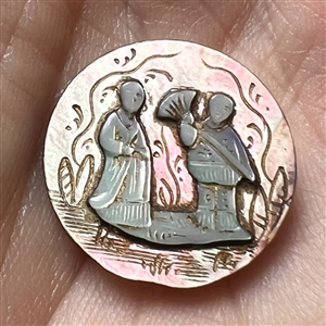 Iridescent pearl of Asian couple over smoky pearl button.