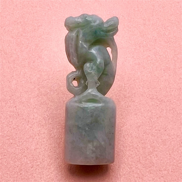 Carved jade button of a fabulous creature.