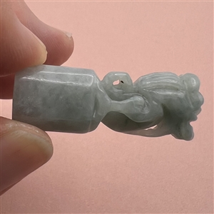 Carved jade button of a fabulous creature.